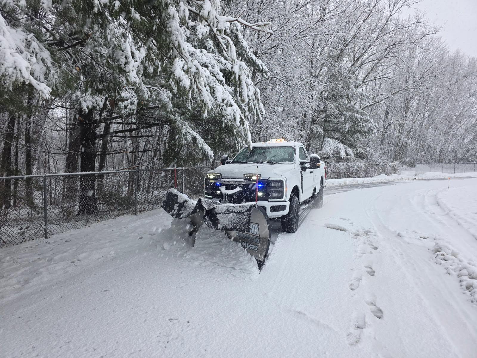 Commercial snow plow clearing a business parking lot in Wisconsin